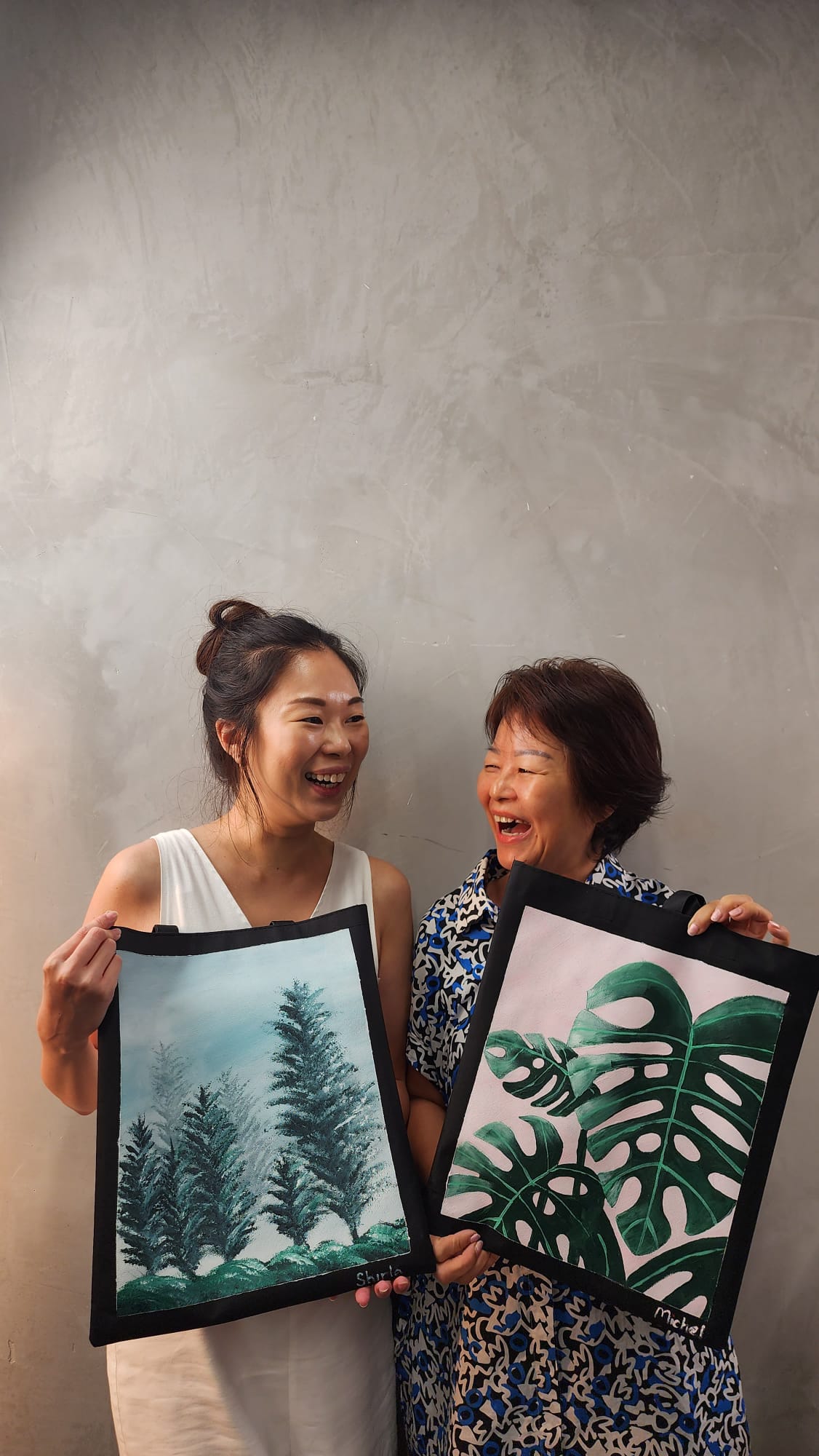 Students posing with finished artwork from Hustle's Acrylic Painting Workshop